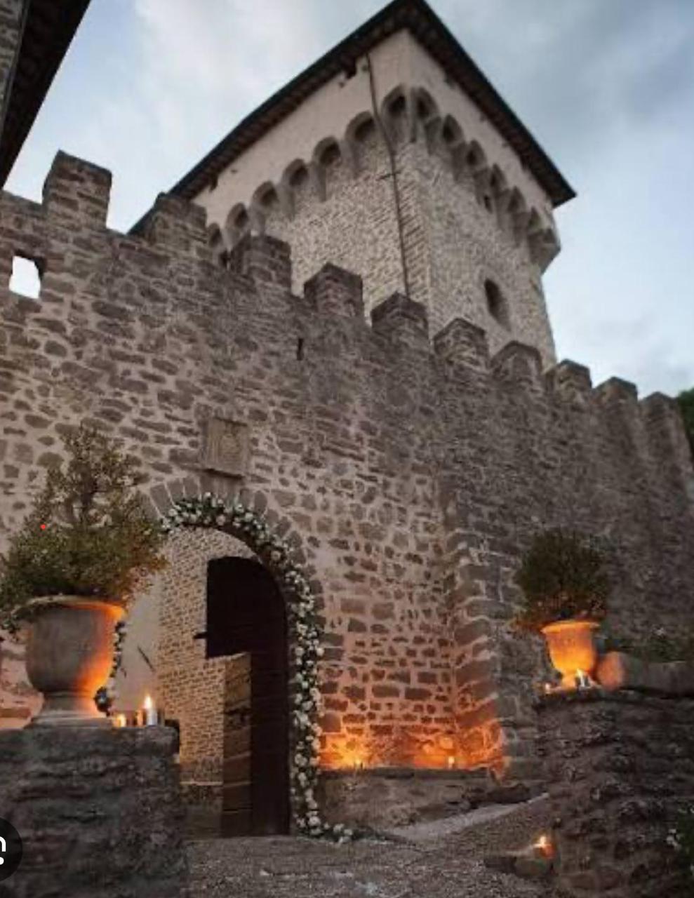 Ingresso in pietra e torre merlata del castello al crepuscolo